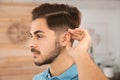 Young man adjusting hearing aid Royalty Free Stock Photo