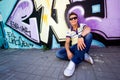 Young man against graffiti wall