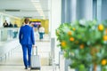Young man in airport. Casual young boy wearing suit jacket. Caucasian man with cellphone at the airport while waiting Royalty Free Stock Photo