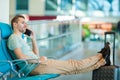 Young man in an airport lounge waiting for flight aircraft. Caucasian man with smartphone indoor Royalty Free Stock Photo
