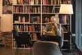 Young man alone escapes from the noise and obligations of marriage and work, sitting in a library or bookstore, reads a book in