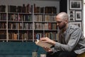 Young man alone escapes from the noise and obligations of marriage and work, sitting in a library or bookstore, reads a book in