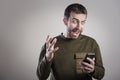 Man angry at his phone, outraged and enraged Royalty Free Stock Photo