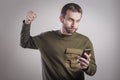 Man angry at his phone, outraged and enraged Royalty Free Stock Photo