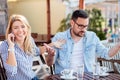 Young man is annoyed as his girlfriend spends too much time talking on the phone