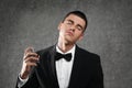 young man applying perfume on grey stone background Royalty Free Stock Photo