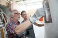 Young man apprentice with professional plasterer