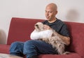 Young man with an arm cast petting his cat Royalty Free Stock Photo
