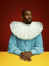 Young man as a medieval grandee on red background