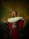 Young man as a medieval knight on dark background