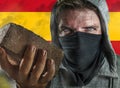 Young man as ultra and extremist Spanish nationalism defender. violent protester in face mask holding a brick at fighting riot in