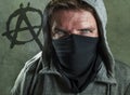 Young man as violent and ultra anarchist rioter . furious anti-system protester in face mask hostile at fighting riot in radical