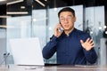 Young man, Asian businessman, student, talking on the phone with clients and partners in the office Royalty Free Stock Photo