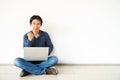 Young man asian sitting on the floor with using computer laptop happy excited with big smile posing isolated over white wall Royalty Free Stock Photo