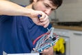 Young man assembles electronic computer components with his own hands. Hobby, technician, do-it-yourself assembly and invention