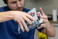 Young man assembles electronic computer components with his own hands. Hobby, technician, do-it-yourself assembly and invention Royalty Free Stock Photo