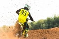 A young man, a man, an athlete, driving a motocross motorcycle on a dirt track. Movement, slow motion. Nature, field. A Royalty Free Stock Photo