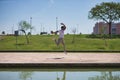 Young man, attractive and Hispanic, wearing a white t-shirt and hat, jumping in the air very happy, in an outdoor park. Concept,