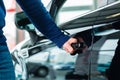 Young man with auto in car dealership Royalty Free Stock Photo