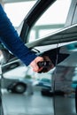 Young man with auto in car dealership Royalty Free Stock Photo