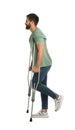 Young man with axillary crutches on white background