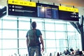 Young man with backpack in airport near flight timetable. Travel Royalty Free Stock Photo