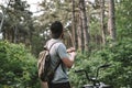 Young man with backpack cycling on a forest path, active lifestyle