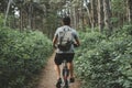 Young man with backpack cycling on a forest path, active lifestyle