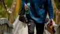 Young man with a backpack, guitar and bottle of water walking on the bridge