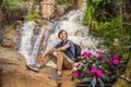 Young man with backpack standing near a waterfall in forest. Male hiker in the nature Royalty Free Stock Photo