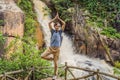 Young man with backpack standing near a waterfall in forest. Male hiker in the nature Royalty Free Stock Photo