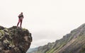 Young Man With Backpack Standing On Rocky Stone In Summer Mountains And Looking Into The Distance. Wanderlust Travel Concept