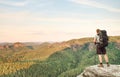 Young man with backpack standing on top of mountain and enjoying mountain view. Hiker on the mountain top. Sport and active life Royalty Free Stock Photo