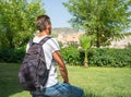 Young man with backpack, tourist, looks view of the ruins of the