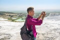 Young man with backpack, tourist, takes pictures with his mobile