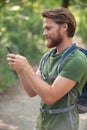 young man with backpack using smart phone in nature Royalty Free Stock Photo