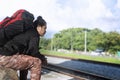 Young man with backpack waiting for next the train station. Royalty Free Stock Photo