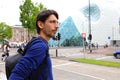 Young man with backpack waiting taxi or bus in Mathildelaan main street in Eindhoven, Netherlands