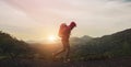 Young man with backpack  walking on path and heading to foggy mountain and sunrise in the morning. Tourist traveler on background Royalty Free Stock Photo