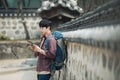 Young man backpacking in Korea. sitting in a Korean traditional house and using a tablet computer. Royalty Free Stock Photo