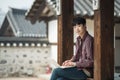 Young man backpacking in Korea. using a laptop sitting in a Korean traditional house. Royalty Free Stock Photo