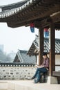 Young man backpacking in Korea. using a laptop sitting in a Korean traditional house. Royalty Free Stock Photo