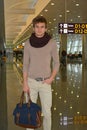 Young man with bag standing in airport hall Royalty Free Stock Photo