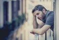 Young man at balcony in depression suffering emotional crisis Royalty Free Stock Photo