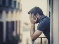 Young man at balcony in depression suffering emotional crisis Royalty Free Stock Photo