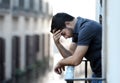 Young man at balcony in depression suffering emotional crisis and grief Royalty Free Stock Photo