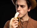 Young man with banana on black