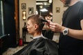 Young man in a barber shop getting a haircut. Side view