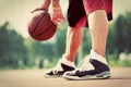 Young man on basketball court dribbling with ball