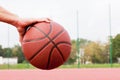 Young man on basketball court. Sitting and dribbling with ball Royalty Free Stock Photo